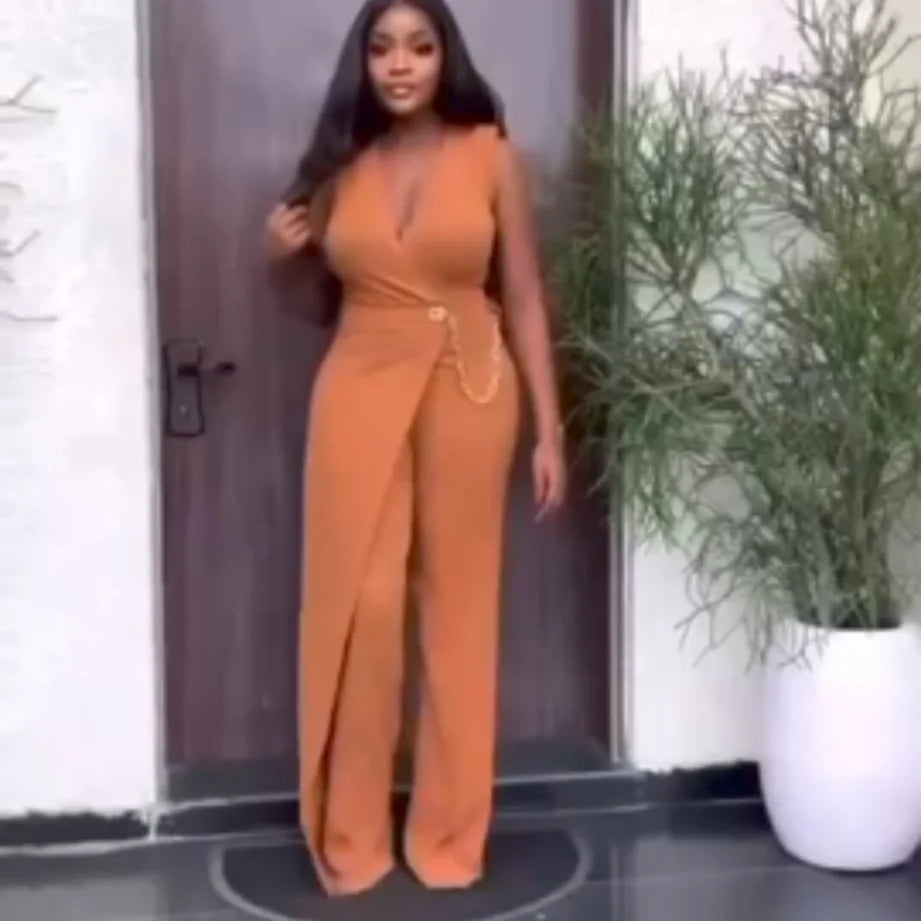 Cette combinaison porte-feuille orange sans manches incarne l'élégance intemporelle avec ses détails raffinés. La délicate chaînette qui orne le devant ajoute une dimension sophistiquée, tandis que la coupe fluide épouse harmonieusement les courbes pour un rendu flatteur et confortable. Le style enveloppant du porte-feuille crée une silhouette élancée, idéal pour valoriser votre morphologie. Versatile et tendance, cette pièce passe sans effort d'une journée décontractée à une soirée chic. La teinte orange v