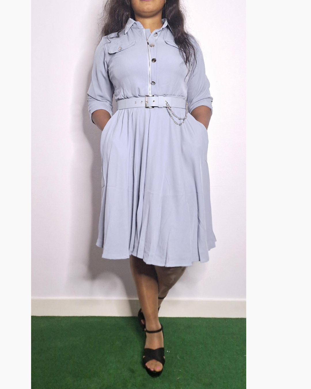 Découvrez l'élégance intemporelle avec cette robe grise aux détails raffinés. La ceinture ornée d'une chainette délicate épouse votre silhouette avec grâce, créant une définition flatteuse au niveau de la taille. Ses manches trois quarts offrent la polyvalence idéale : suffisamment couvrantes pour les journées fraîches, assez dégagées pour les transitions saisonnières. Que vous la portiez au bureau, à un événement ou en sortie casual, cette pièce polyvalente s'adapte à vos envies du moment. Confectionnée po