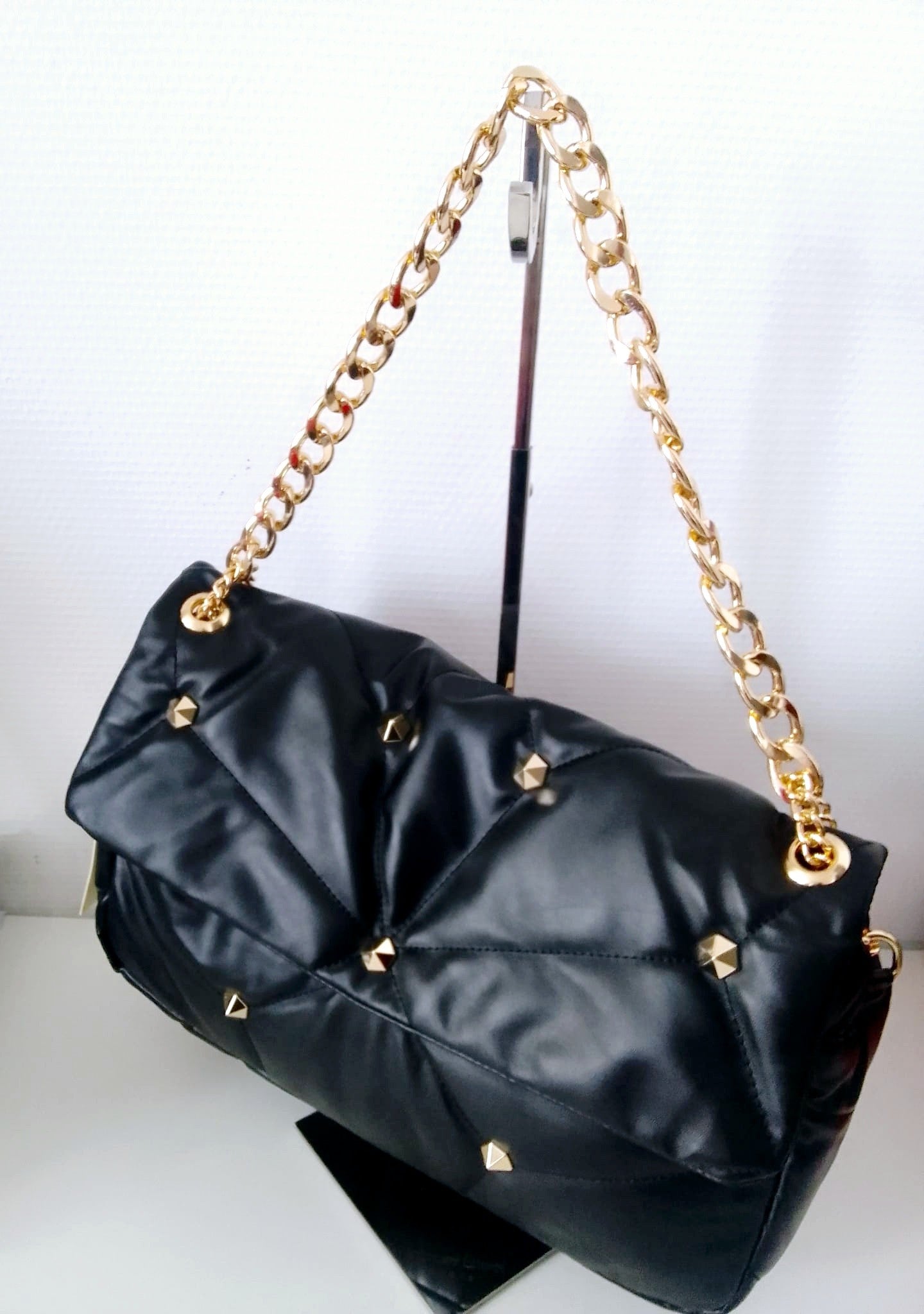 Ce sac fourre-tout noir incarne l'équilibre parfait entre fonctionnalité et élégance intemporelle. Ses perles délicates et sa chaîne raffinée transforment un accessoire du quotidien en pièce de caractère qui complète sans effort vos tenues, du casual au soirée. Avec son ample capacité, il accueille tous vos essentiels tout en conservant une silhouette épurée et sophistiquée. Les finitions soignées révèlent une attention particulière aux détails, typique des pièces premium. Que vous le portiez en main ou en 