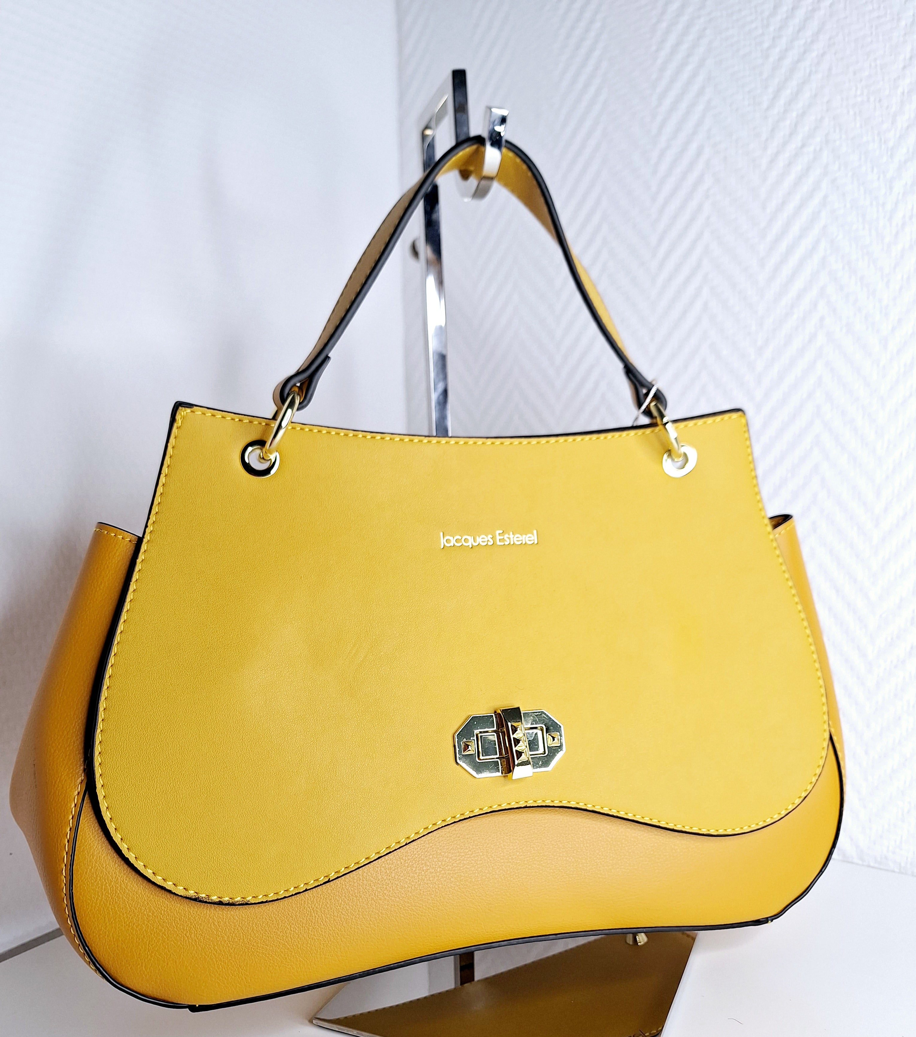Le Sac Jacques Esterel incarne l'alliance parfaite entre sophistication et polyvalence. Ses deux nuances de jaune—clair et foncé—créent un contraste visuel captivant qui transforme instantanément n'importe quelle tenue. Conçu pour les femmes qui refusent de compromettre entre style et praticité, ce sac signature offre une capacité généreuse tout en conservant des proportions élégantes. Que vous le portiez au bureau, en sortie ou en weekend, sa construction soignée et son design intemporel en font un investi