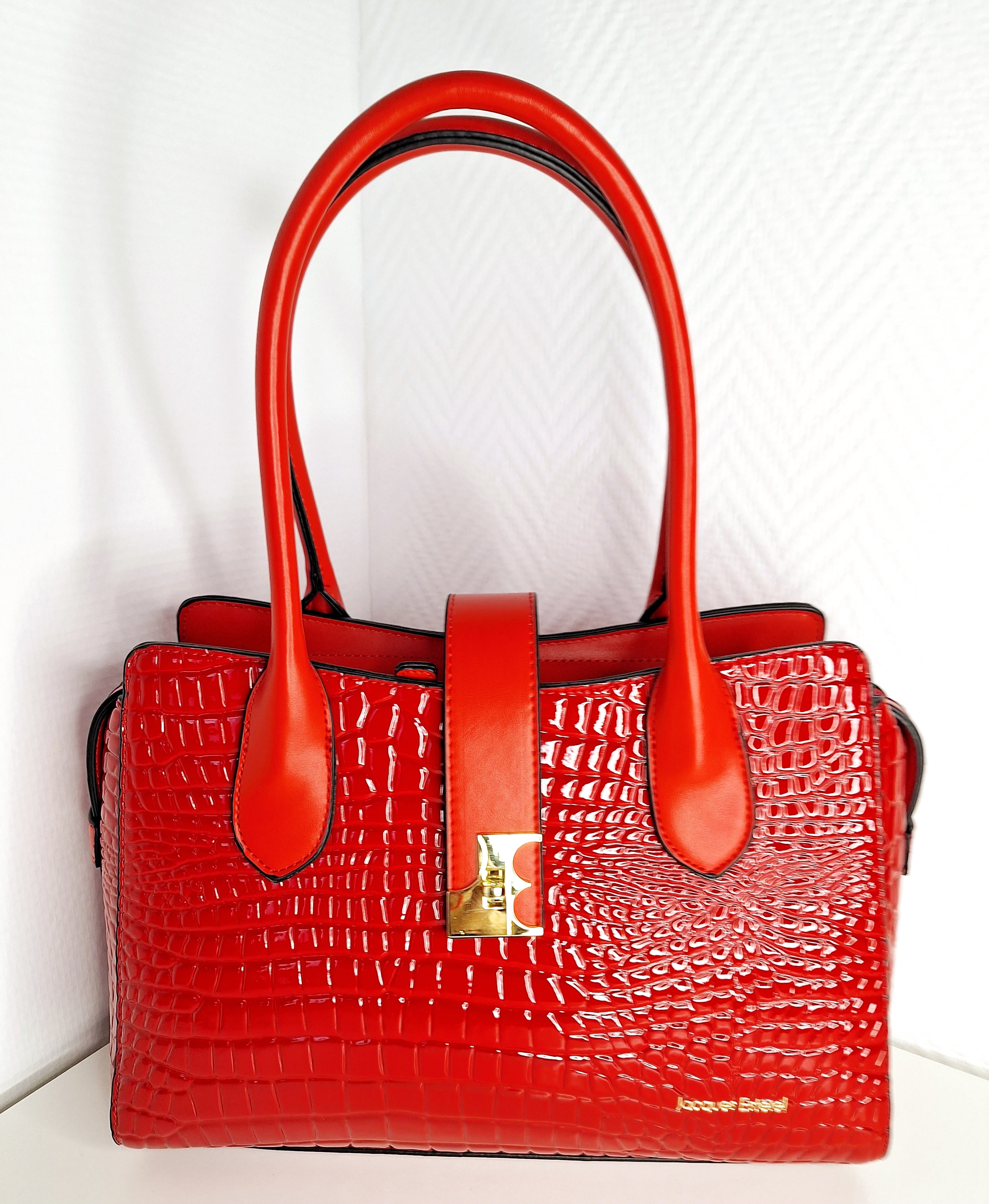 Le sac Jacques Esterel Croco Rouge incarne l'audace et la sophistication. Confectionné en cuir texturé avec un effet crocodile distinctif, il apporte une dimension luxueuse à chaque silhouette. Sa teinte rouge éclatante crée un impact visuel immédiat, parfait pour affirmer votre présence en toute occasion. Conçu pour la femme moderne qui refuse les compromis, ce sac allie élégance intemporelle et fonctionnalité. Ses proportions épurées le rendent aussi à l'aise au bureau qu'en soirée, tandis que sa structur