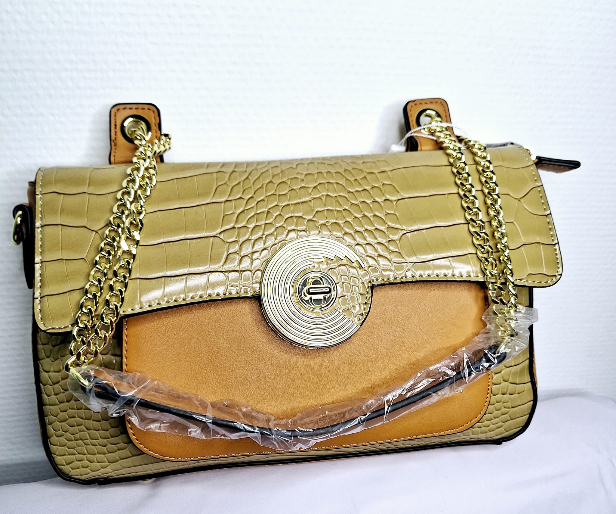 Chic et original, ce sac Jacques Esterel en finition vert croco se distingue par son design sophistiqué et son allure tendance. Sa texture embossée effet crocodile sublime la profondeur du vert, une couleur à la fois élégante et audacieuse. La chaînette dorée, raffinée et brillante, complète son style en apportant une touche glamour.