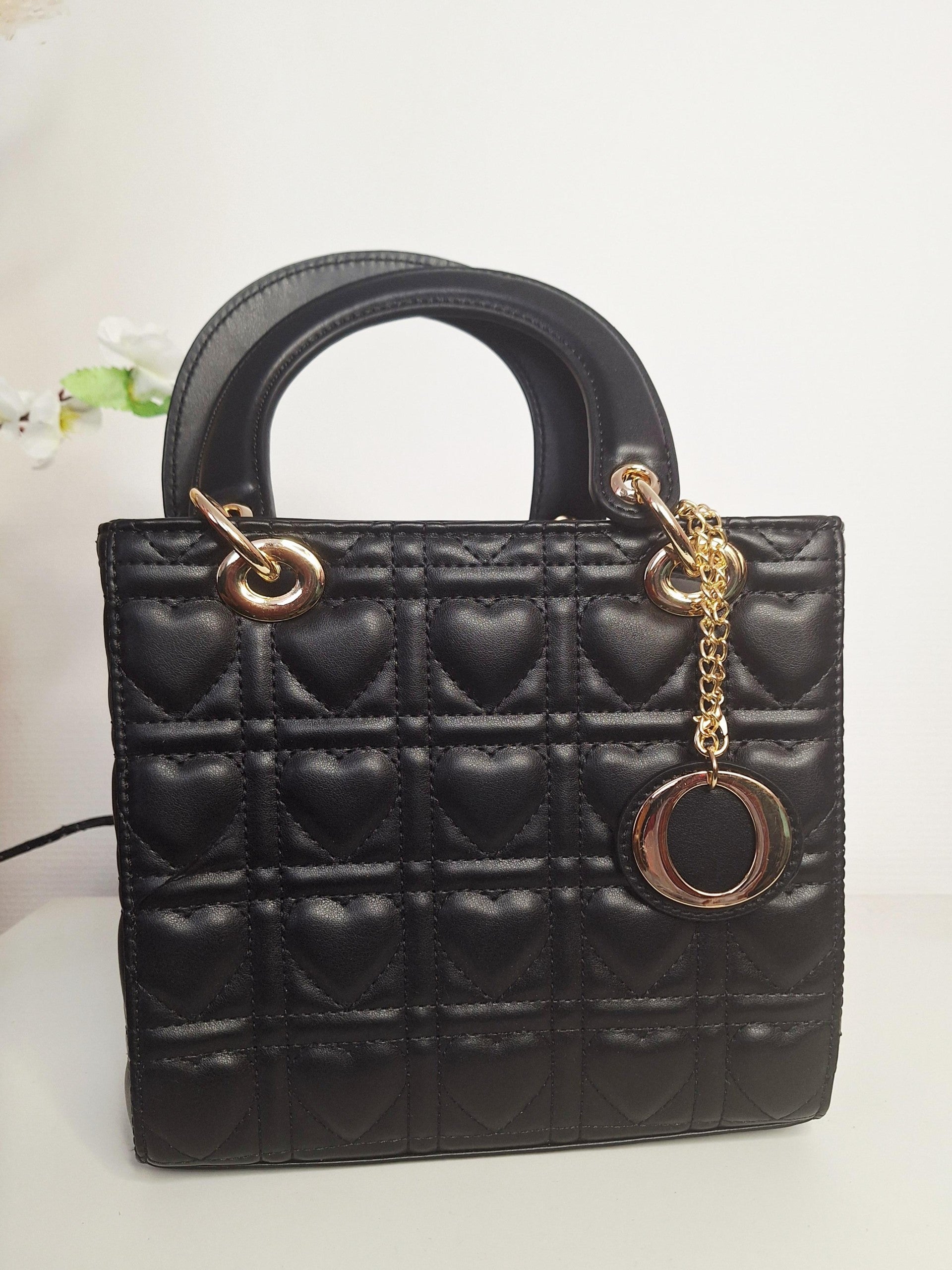 Sac à main carré au design intemporel, ce petit format noir séduira les femmes en quête d'élégance discrète. Orné de délicats motifs cœurs, il allie raffinement et tendresse pour un accessoire chargé d'émotion. Parfait pour accompagner vos sorties du quotidien ou vos occasions spéciales, ce sac combine praticité et style. Sa teinte noire incontournable s'accorde avec n'importe quelle tenue, tandis que ses détails romantiques ajoutent une touche personnelle à votre look. Compact et élégant, c'est l'accessoir