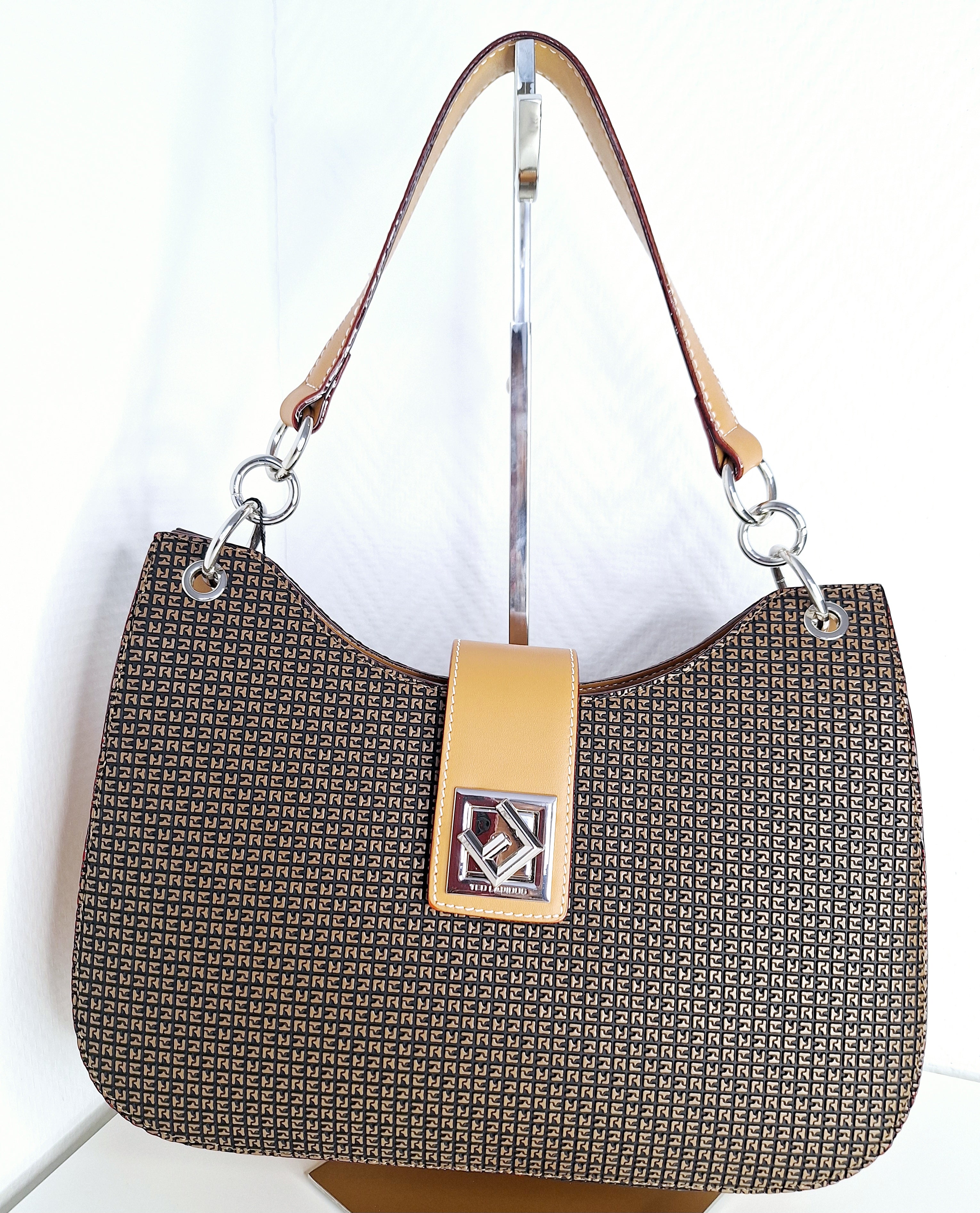 Sac à main Ted Lapidus MIEL : l'accessoire incontournable pour une silhouette affirmée. Cette pièce signature allie élégance intemporelle et praticité, avec sa teinte miel chaleureuse qui s'harmonise sans effort à chaque tenue. Confectionné avec un savoir-faire méticuleux, le cuir travaillé offre une finition premium et une durabilité remarquable. Spacieux et bien structuré, il épouse vos formes avec grâce, du quotidien aux moments privilégiés. Que vous le portiez en bandoulière ou à la main, ce sac incarne