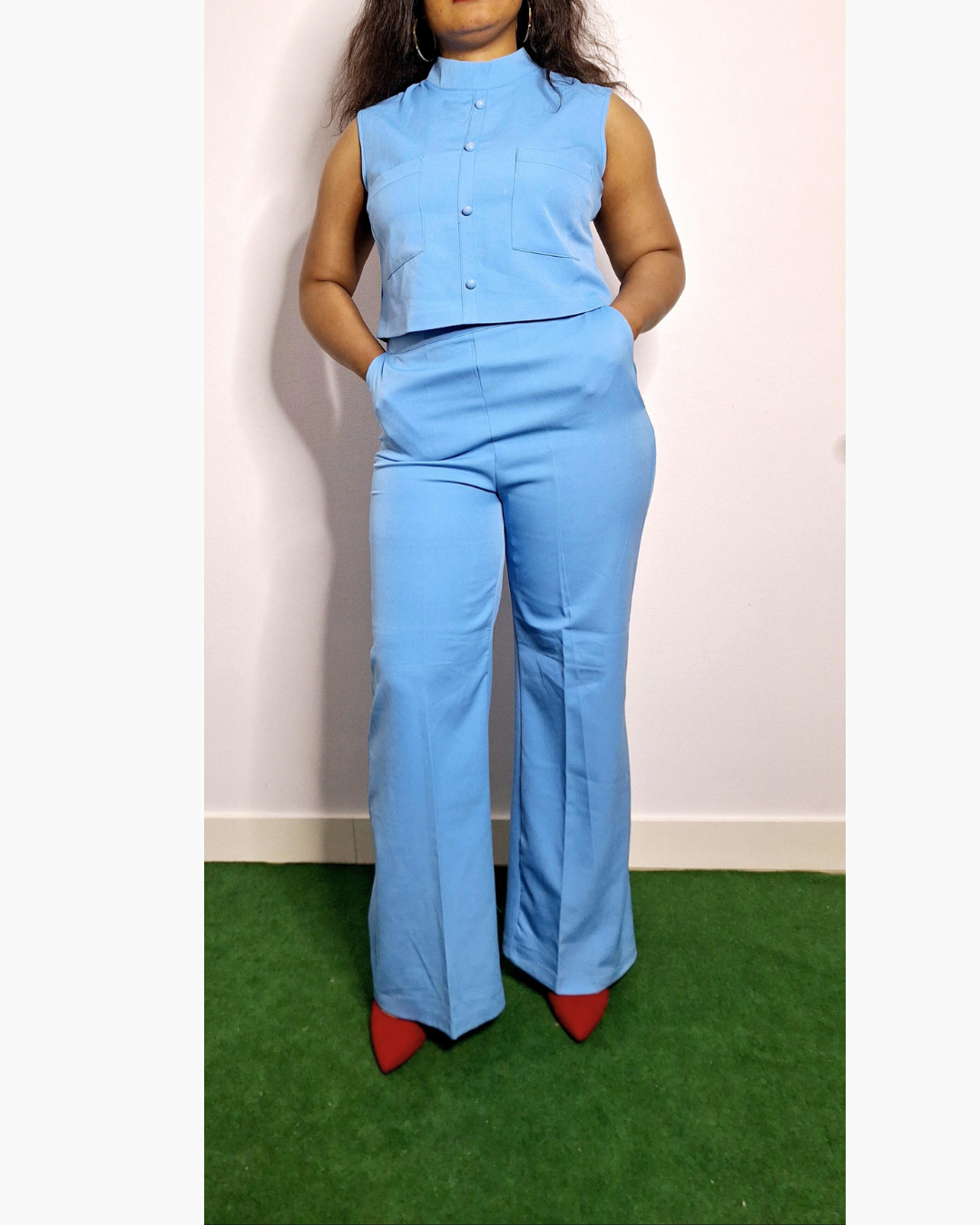 Découvrez cet ensemble pantalon bleu incontournable, alliant sophistication et praticité. Doté d'une taille haute qui affine la silhouette, il épouse vos formes avec élégance tout en offrant un confort optimal. Les poches fonctionnelles vous permettent de garder vos essentiels à portée de main, tandis que les manches courtes assurent une respirabilité parfaite pour les journées chargées. Cette pièce polyvalente se décline en une coupe moderne qui transcende les saisons, passant sans effort du bureau aux sor